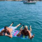 Guests enjoying a private boat trip from Trogir while relaxing in the crystal-clear sea near Kaštela.